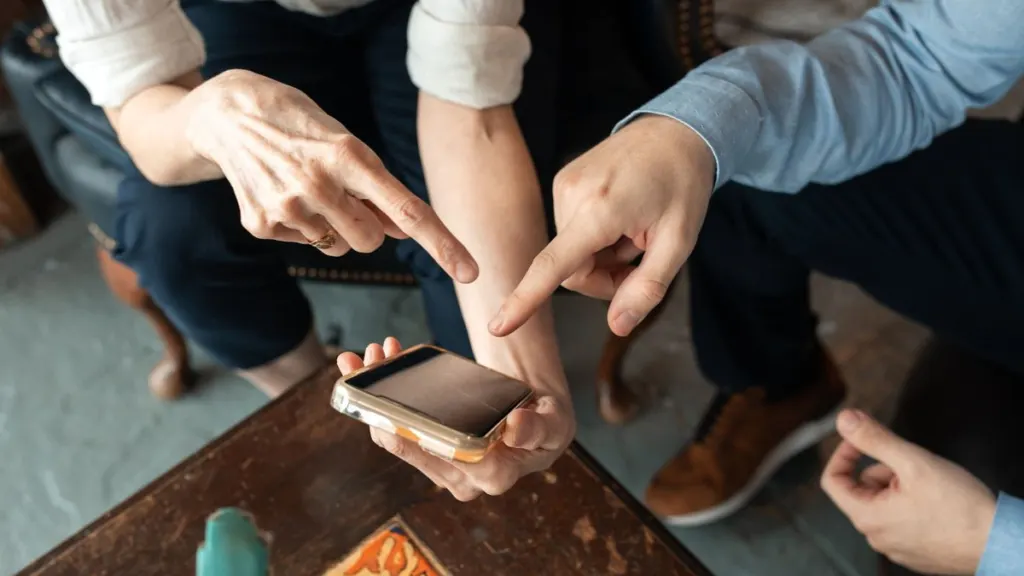 Люди тестируют приложение на смартфоне, обсуждают интерфейс